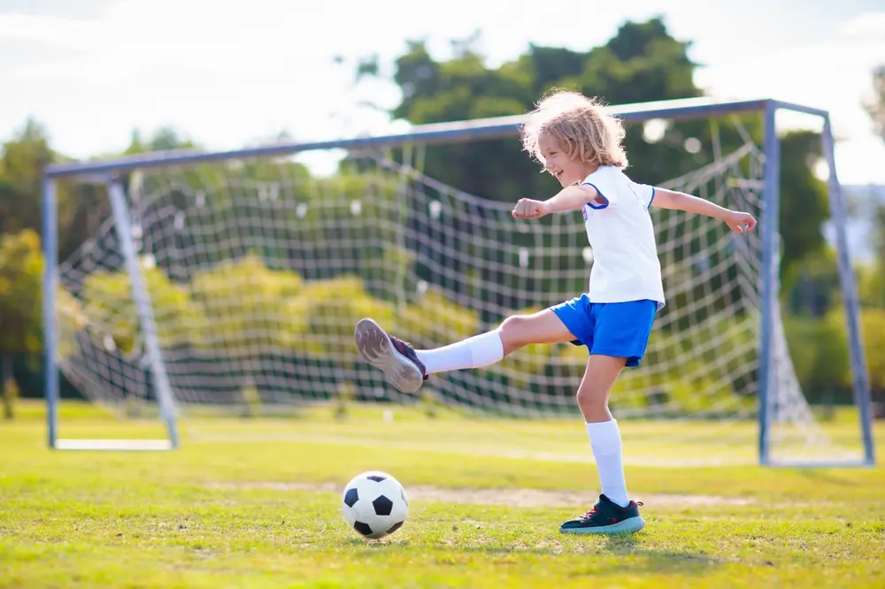 Barn som spiller fotball i hagen